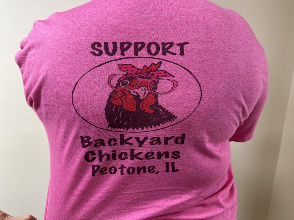 The back of the custom shirts three backyard chicken advocates wore to the March 27th board meeting. Photo by Andrea Arens.