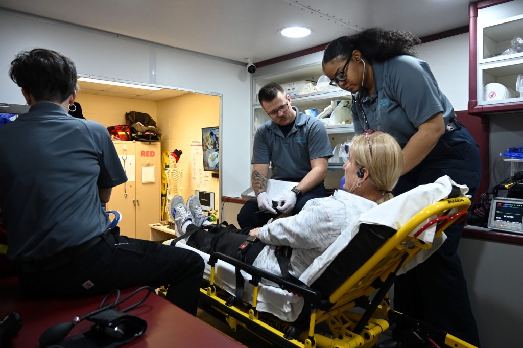 Paramedic students assist a patient inside the ambulance simulator at KCC. –Photo submitted.