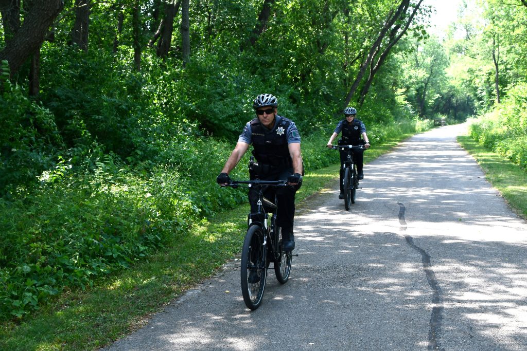 Forest Preserve District of Will County Police Sgt. Dan Olszewski and officer Caitlin Mosier ride bikes on the Wauponsee Glacial Trail in preparation for summer patrols throughout the district. –Photo by Forest Preserve staff, Glenn P. Knoblock.