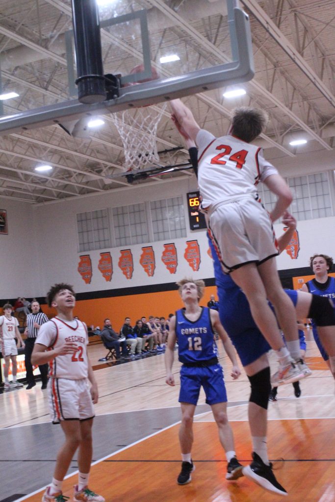 Adyn McGinley, #24, makes that dunk look so easy despite the efforts of a Coal City guard, while Zachary Johnson's face, #22, says it all!! –Photo by Jim Piacentini.