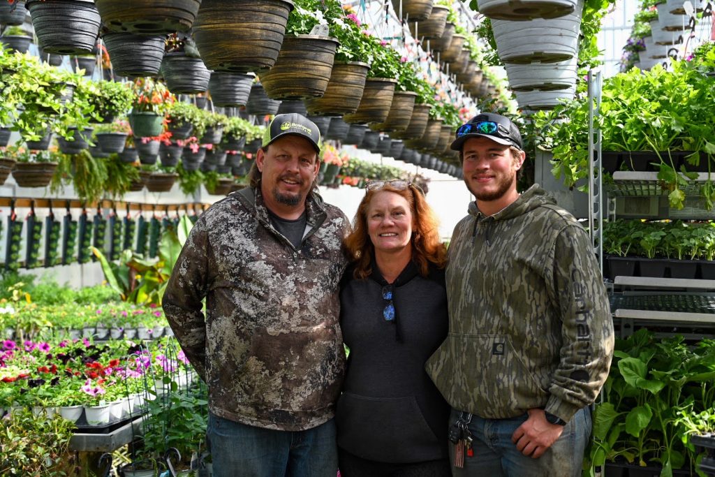 Brad (left), Karen (middle), and Dylan (right) Bothwell pose for a picture in their greenhouse. Photo by Stephanie Irvine.
