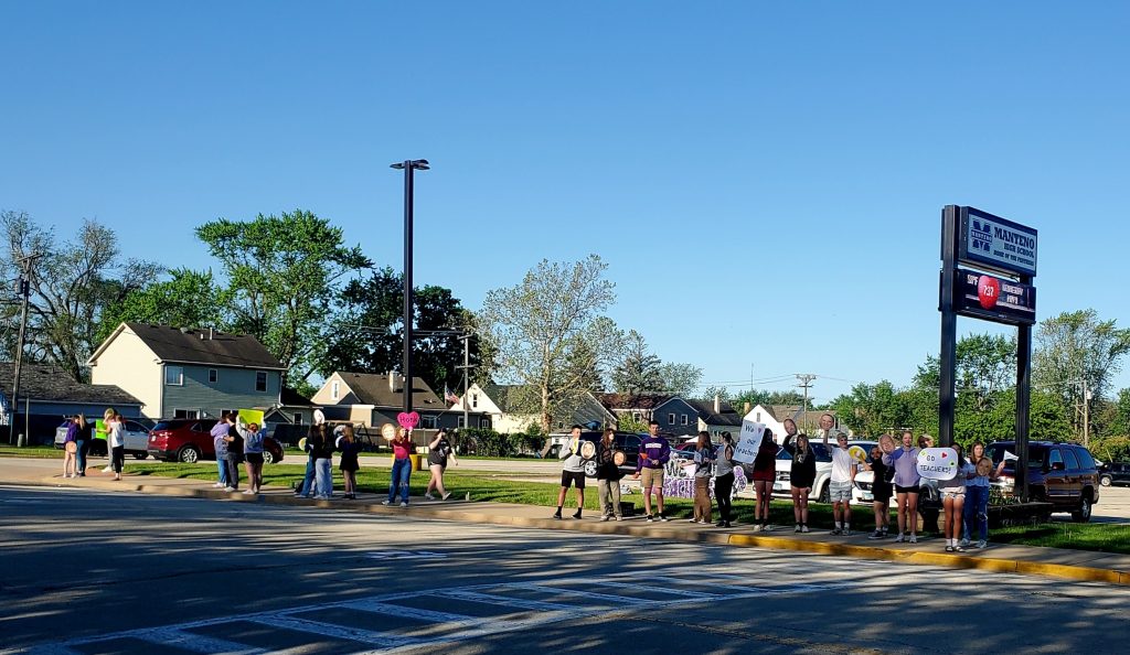 Manteno High School Students lined the entrance of the high school on Monday morning to show their appreciation for the teachers at the beginning of Teacher Appreciation Week. Many were holding signs and teacher faces and encouraged people to honk as they drove by. Photo by Dan Gerber.